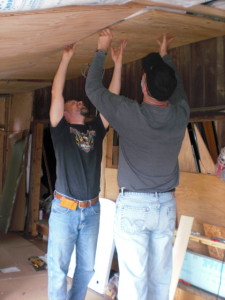 Fellow missionary Tom Carr uses his height to help put up in the ceiling.